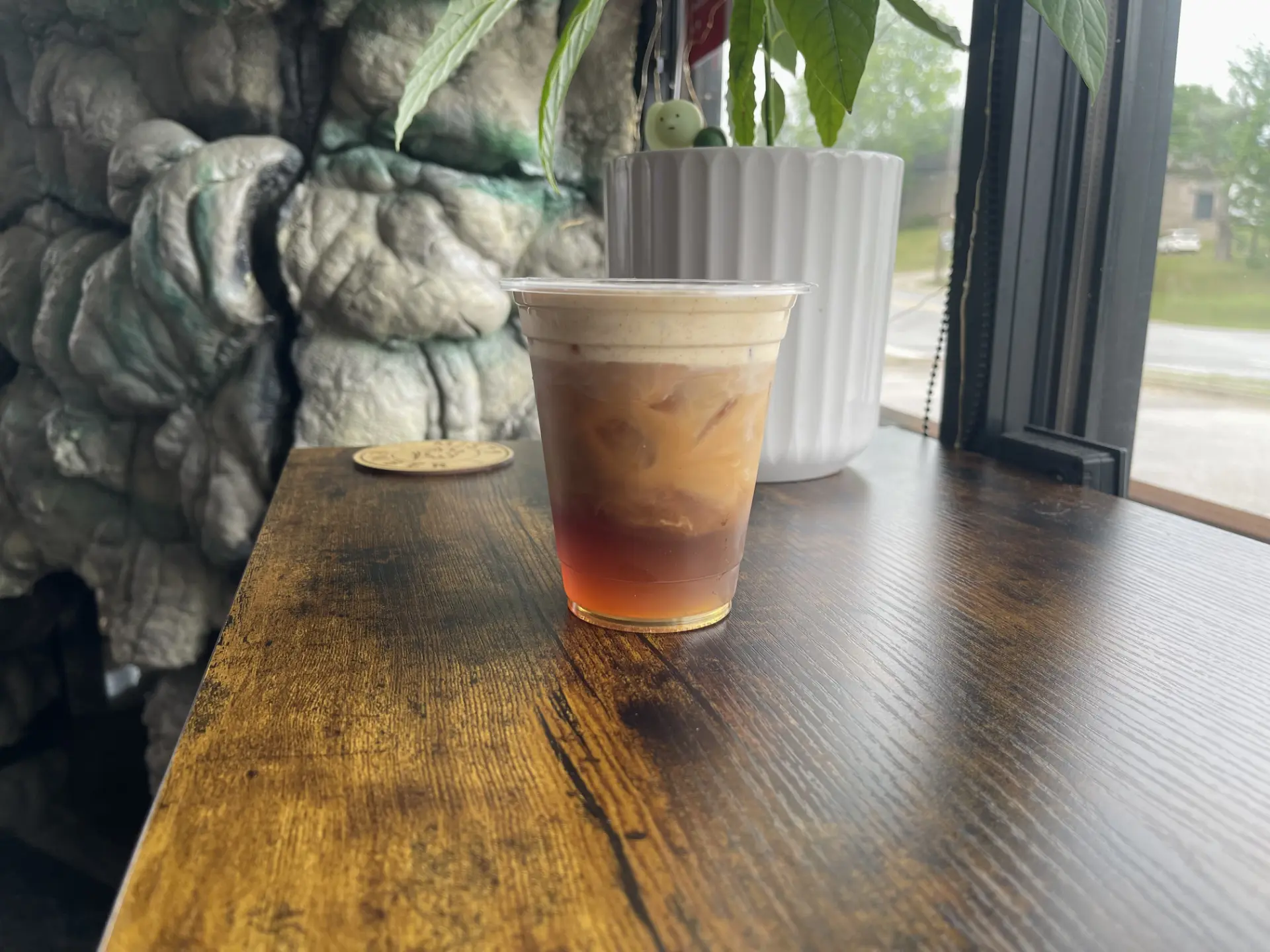 Layered iced drink resting on the café's wooden window ledge
